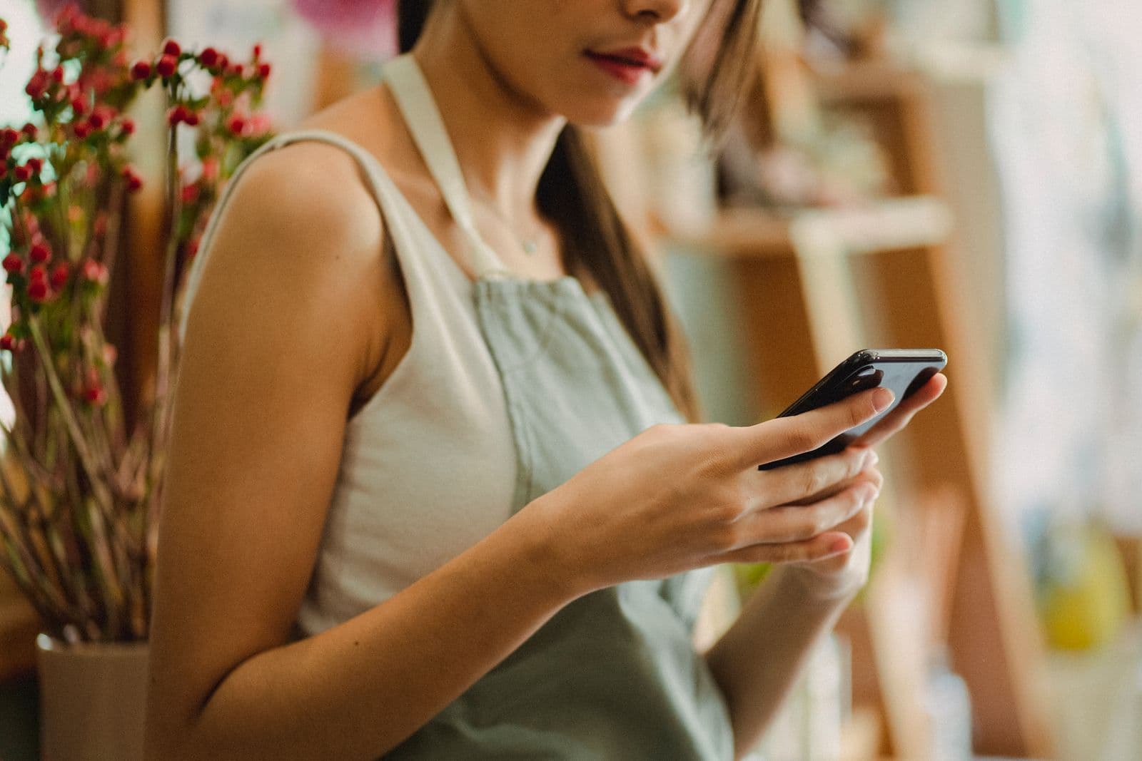 Small business owner using a smartphone in their shop